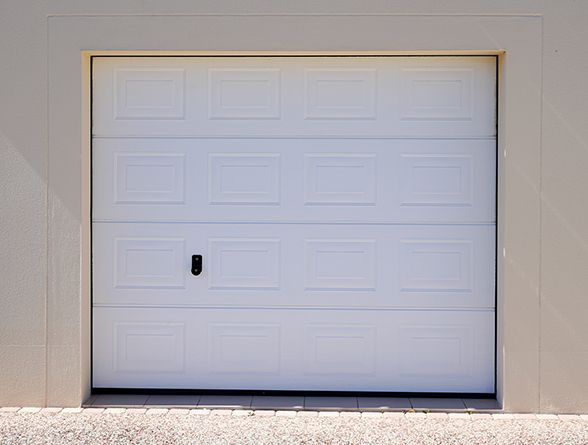 a white garage door is sitting on the side of a building .