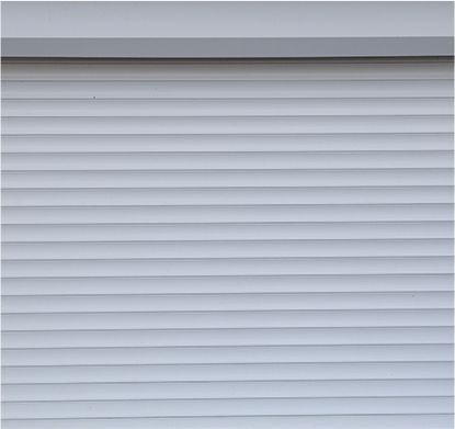 a close up of a white roller shutter on a garage door .