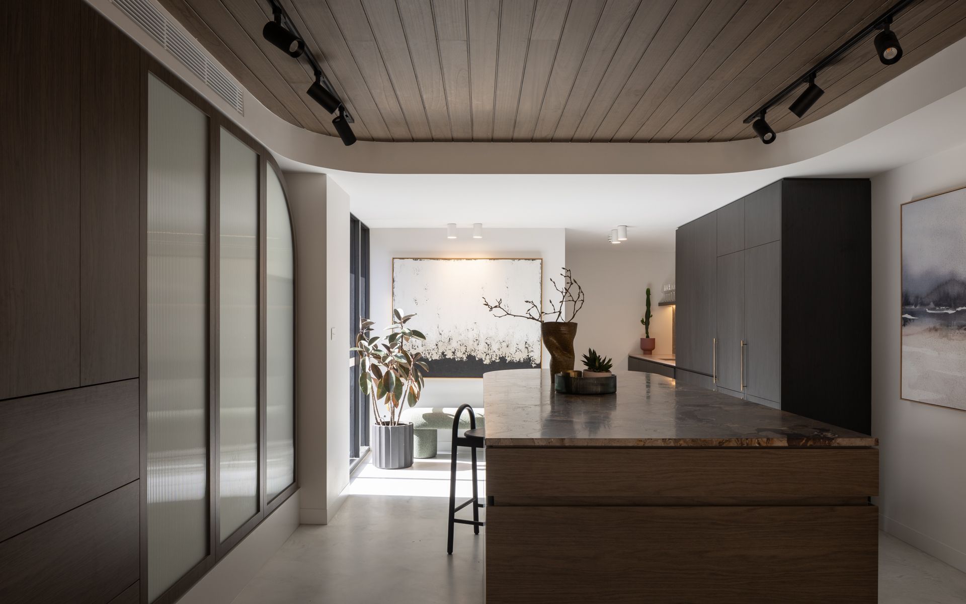 Modern kitchen with wood ceiling, stone countertop, and glass-panelled cabinets. — Goode By Design in Unanderra, NSW