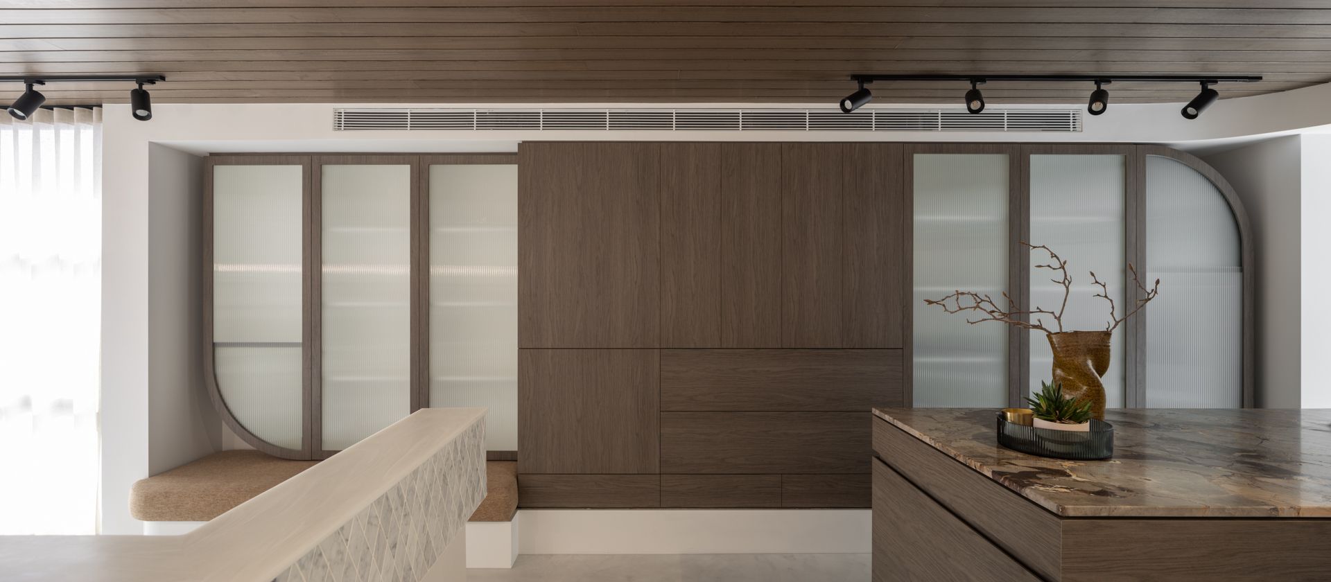 A modern kitchen with wood cabinets, frosted glass doors, and a marble countertop. — Goode By Design in Unanderra, NSW