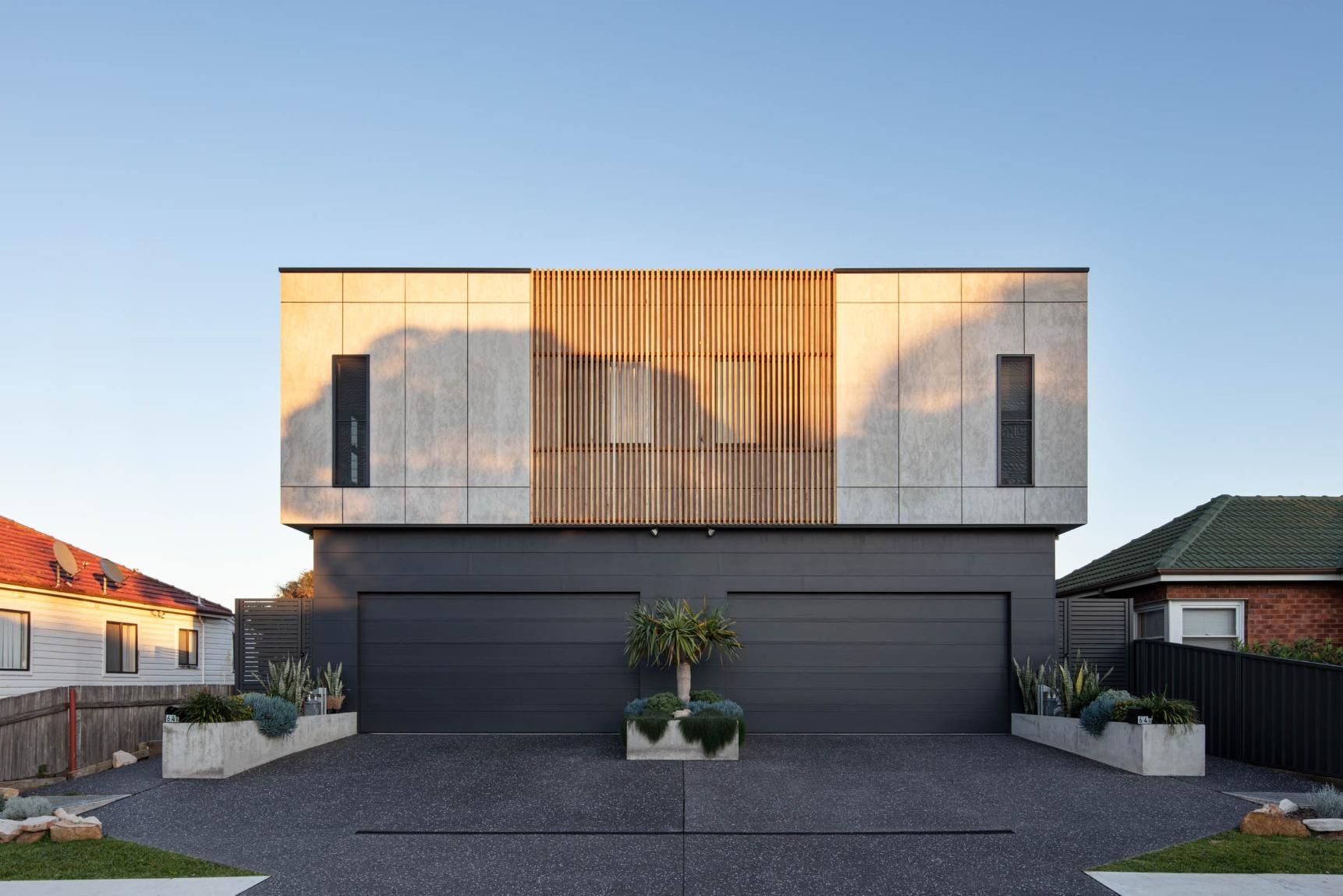 A Modern House with Two Garages and A Driveway in Front of It — Goode By Design in Unanderra, NSW
