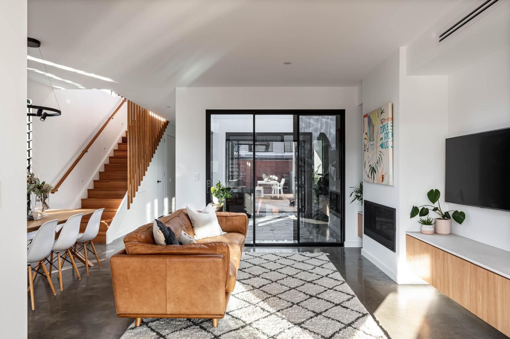A Living Room with A Couch, Chair, Television and Stairs — Goode By Design in Unanderra, NSW