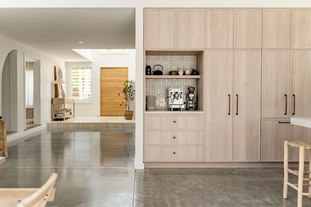 Light wood kitchen cabinetry with coffee station and open hallway view. — Goode By Design in Sydney Joinery, NSW