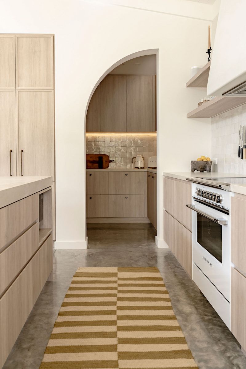 Narrow, Light-wood Kitchen With Arched Doorway — Goode By Design in Unanderra, NSW