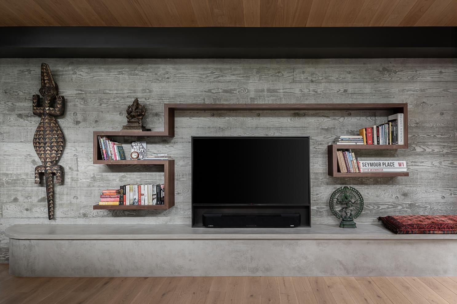 A Living Room with A Concrete Wall, Wooden Shelves and A Flat Screen TV — Goode By Design in Unanderra, NSW