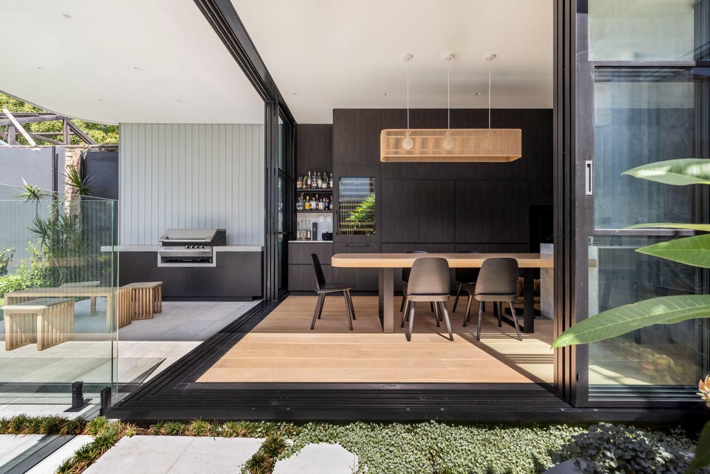 A Kitchen and Dining Room Are Connected by A Sliding Glass Door — Goode By Design in Unanderra, NSW