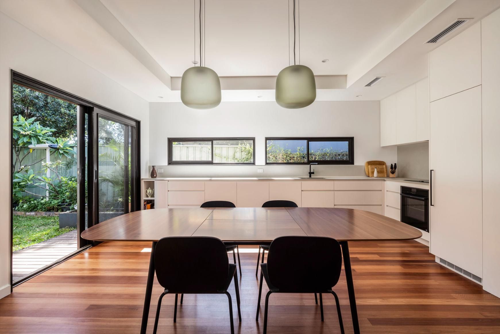 A Dining Room Table and Chairs in A Kitchen with Sliding Glass Doors — Goode By Design in Unanderra, NSW