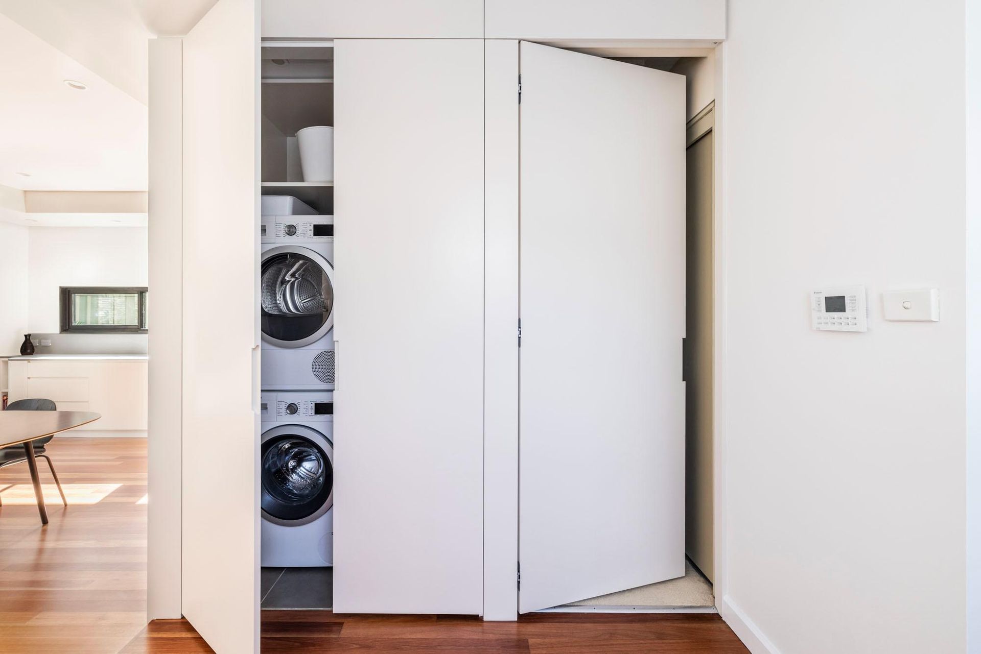 A Washer and Dryer Are Stacked on Top of Each Other in A Closet — Goode By Design in Unanderra, NSW