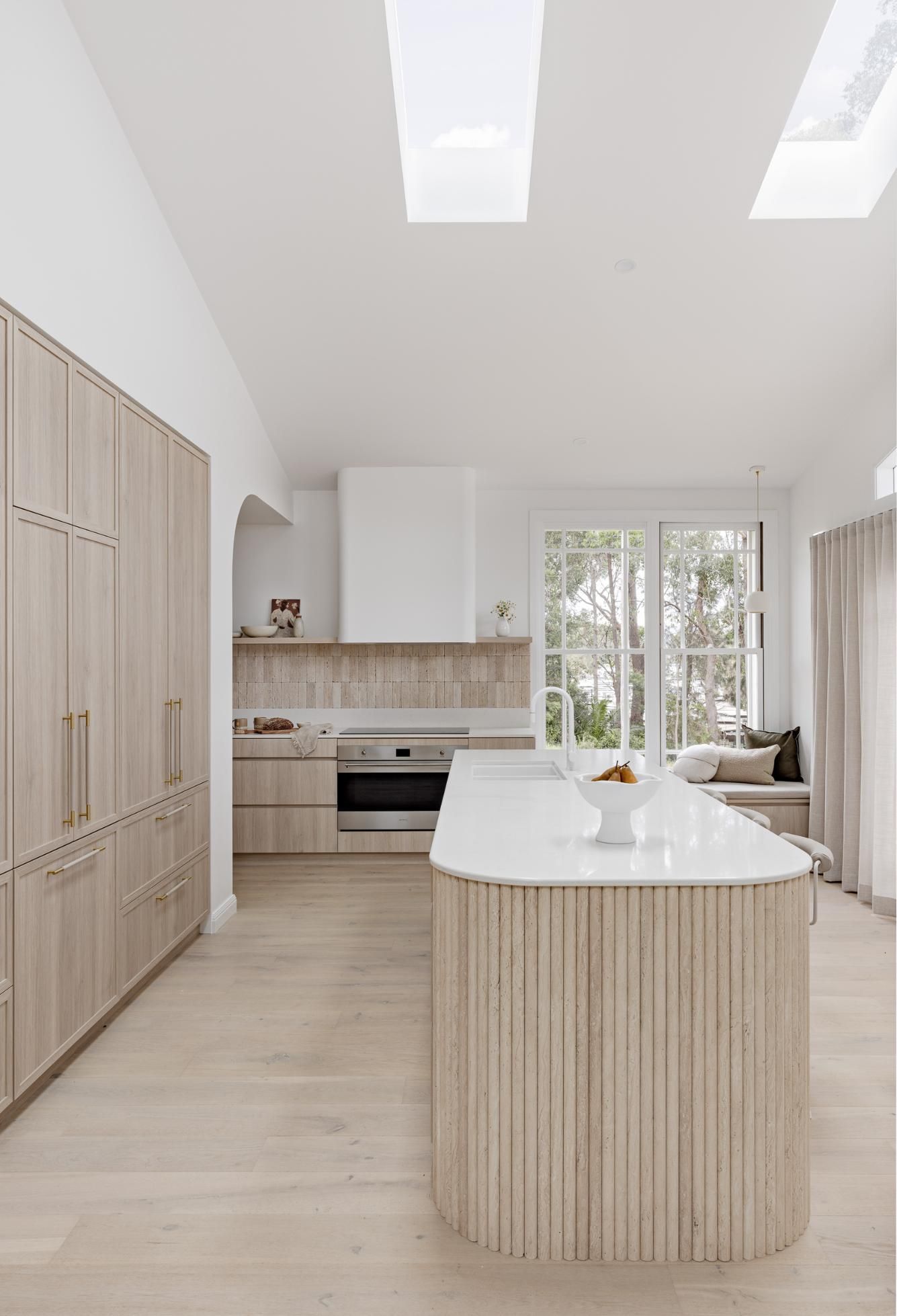 A Kitchen with Wooden Cabinets and A Large Island in The Middle — Goode By Design in Unanderra, NSW
