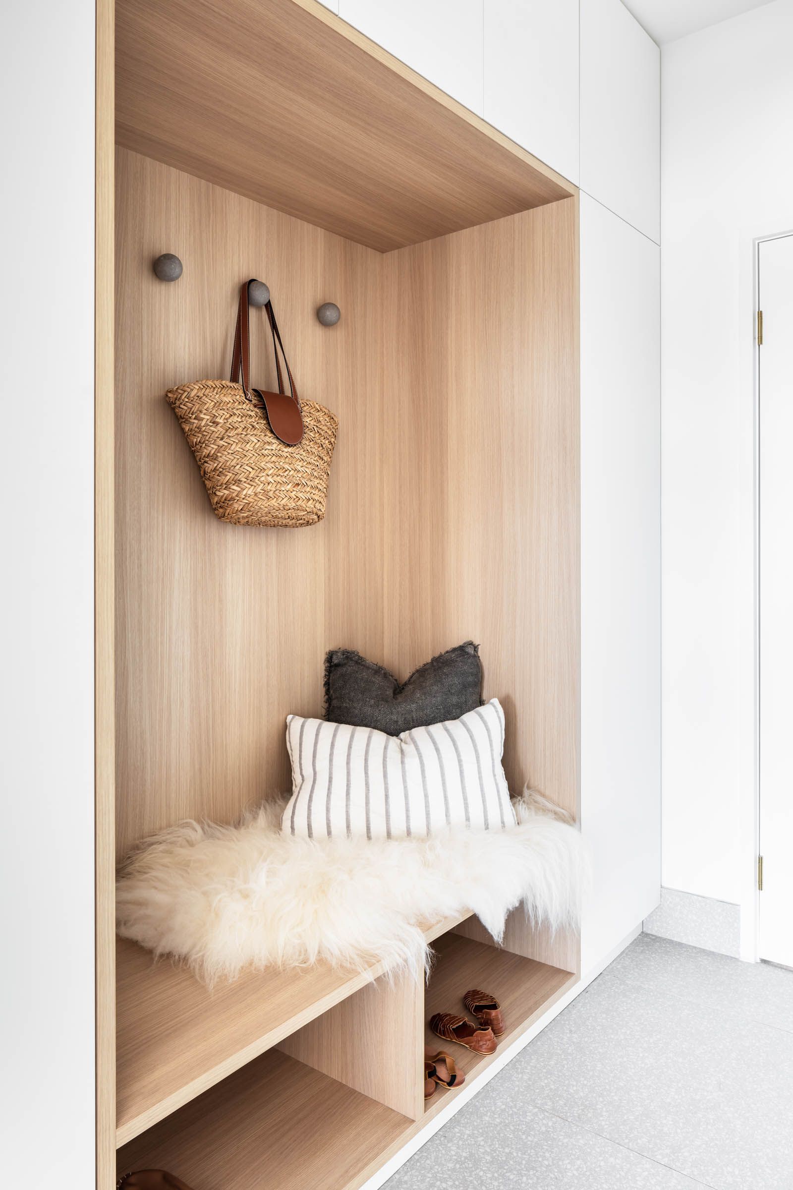 A Wooden Bench with A Pillow and A Wicker Bag Hanging on The Wall — Goode By Design in Unanderra, NSW