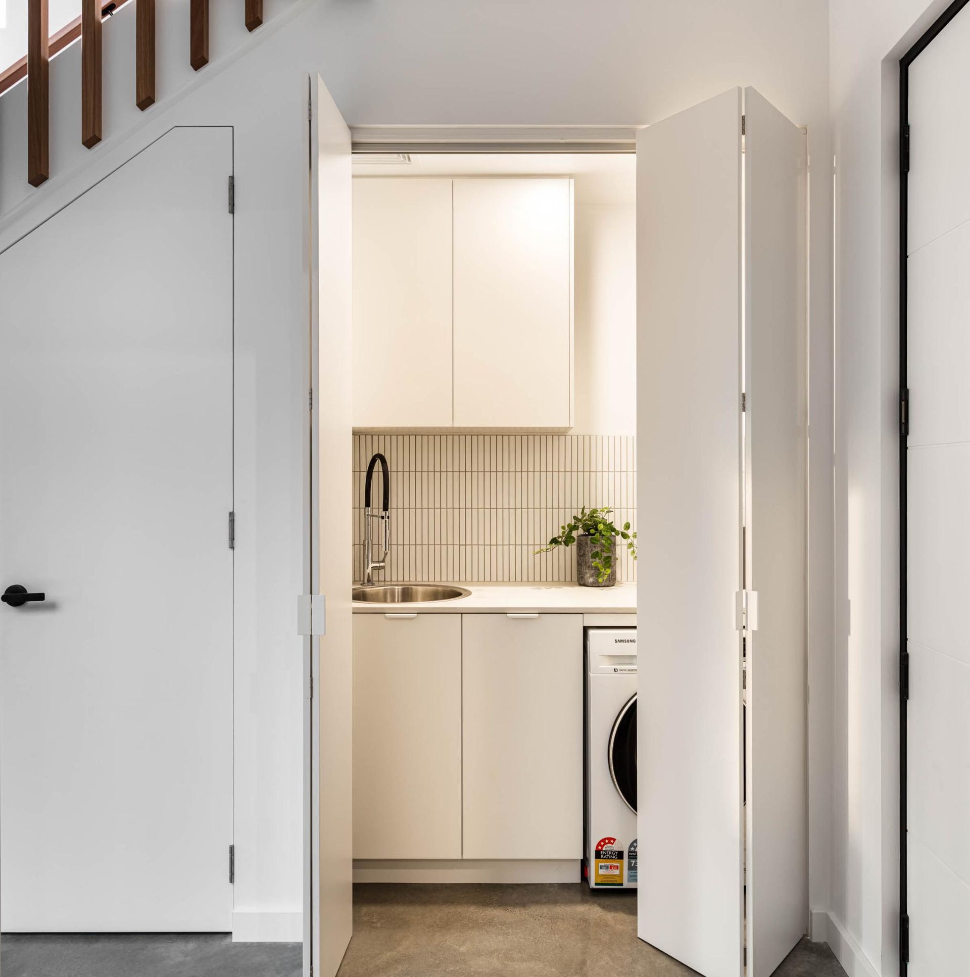 A Laundry Room with White Cabinets and A Washing Machine — Goode By Design in Unanderra, NSW