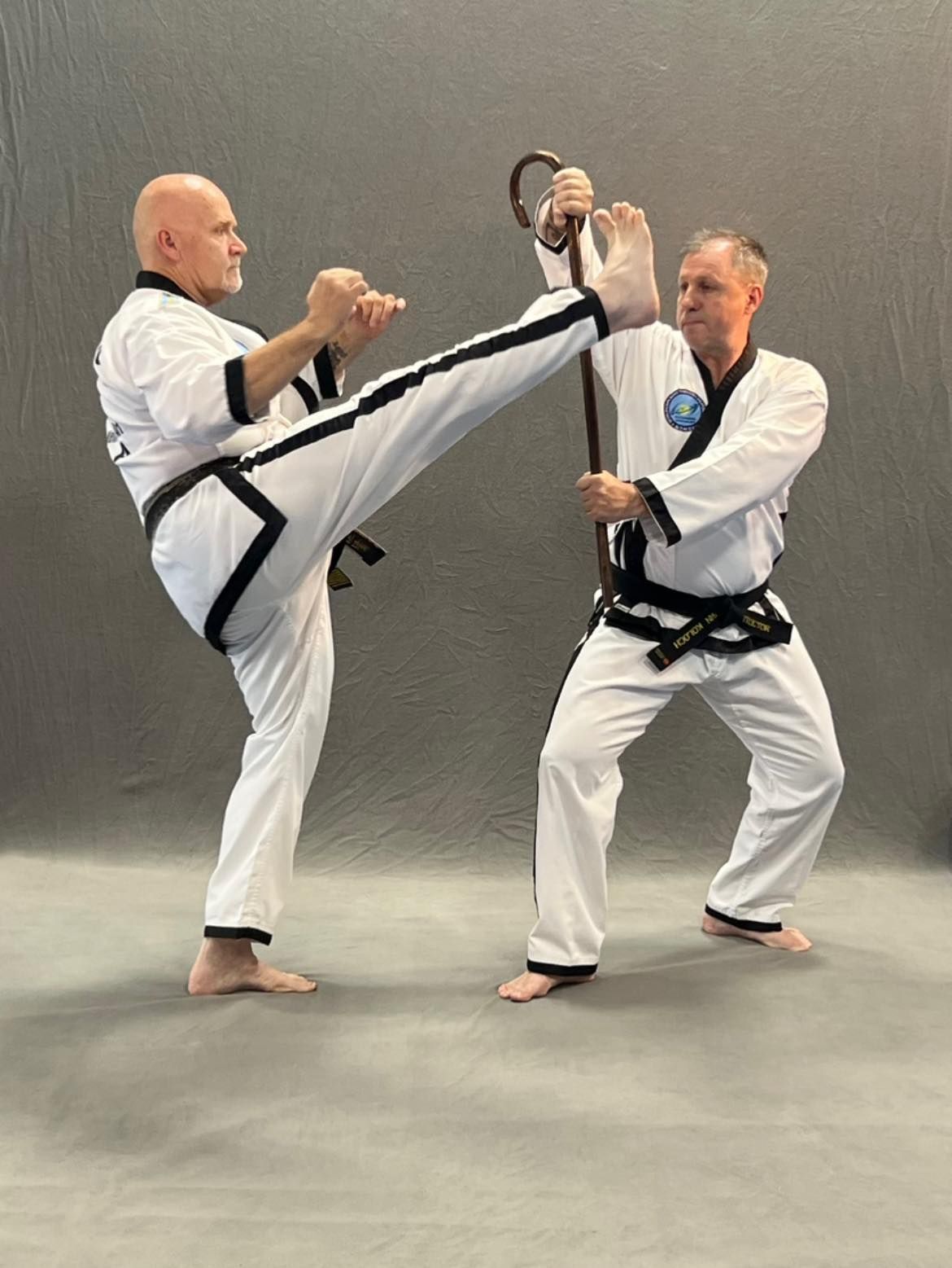 Two men are practicing martial arts in a gym.