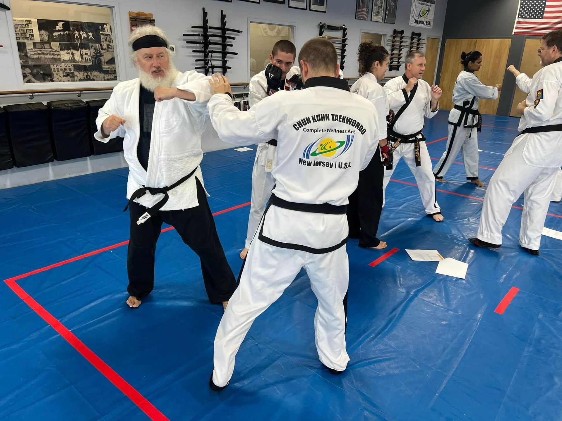 A group of people are practicing martial arts in a gym.