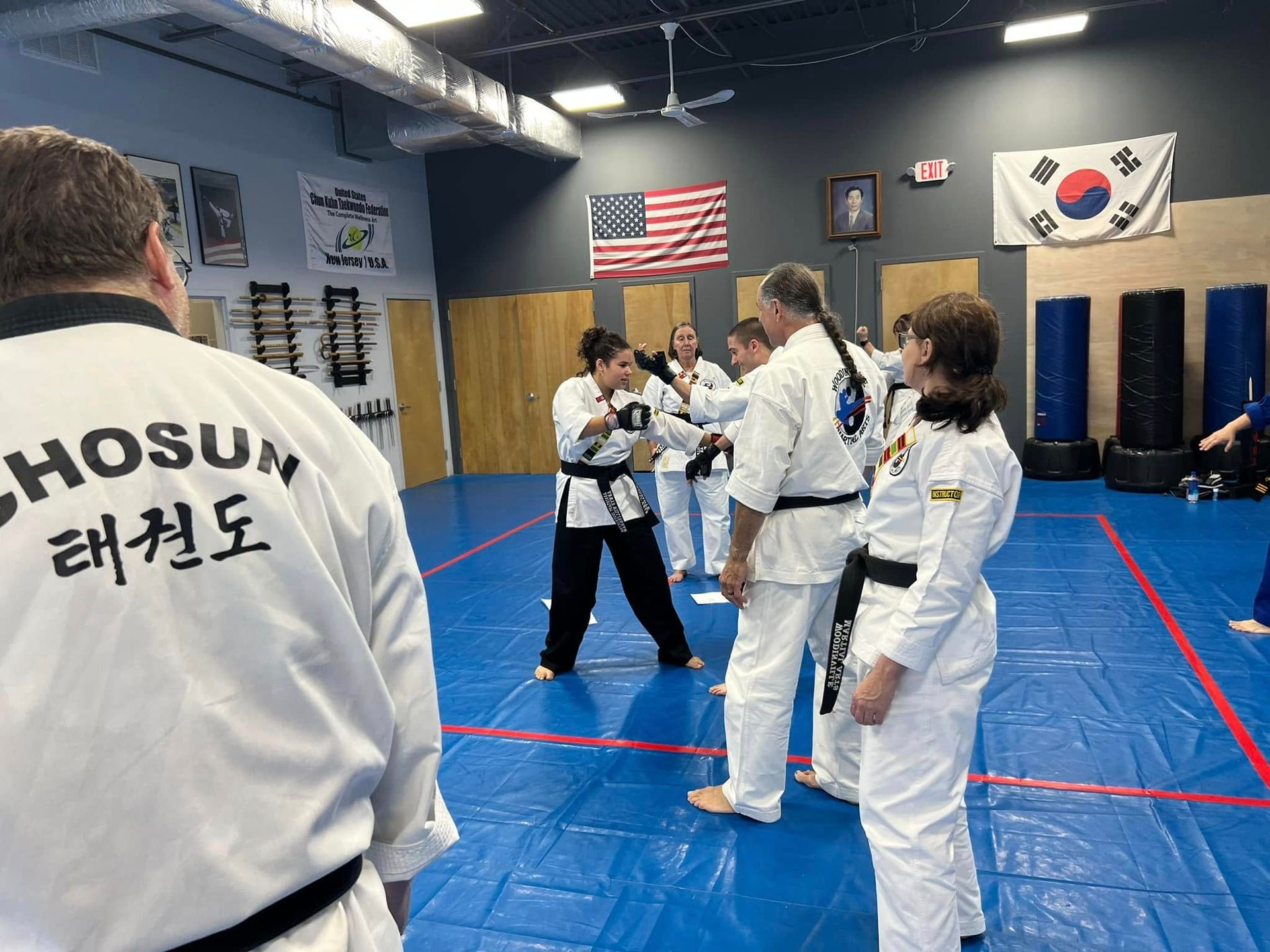 A group of people are practicing martial arts in a gym.