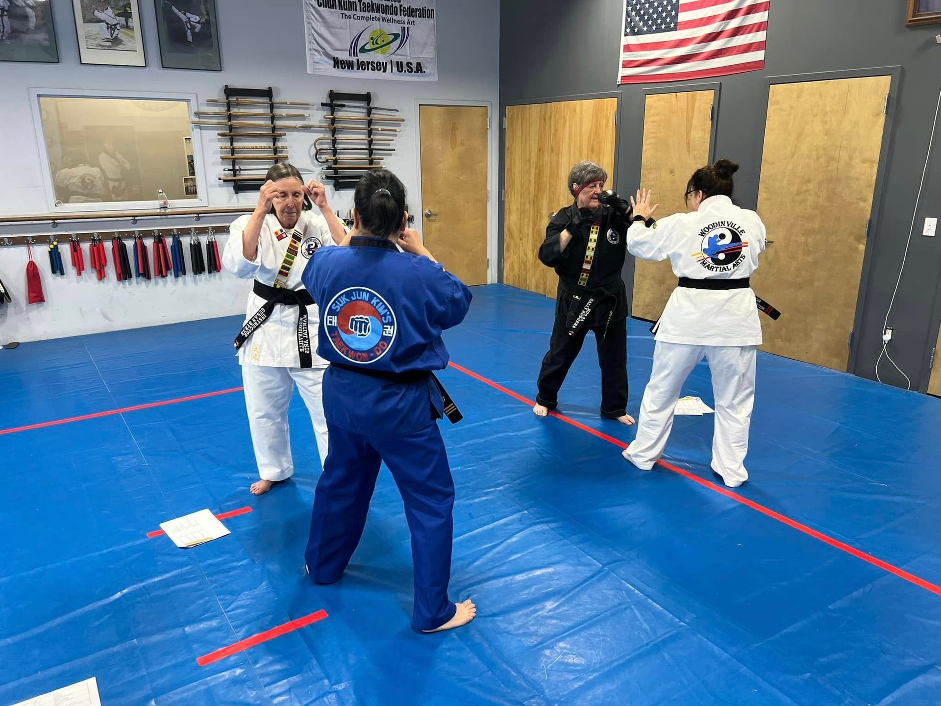 A group of people are practicing martial arts in a gym.