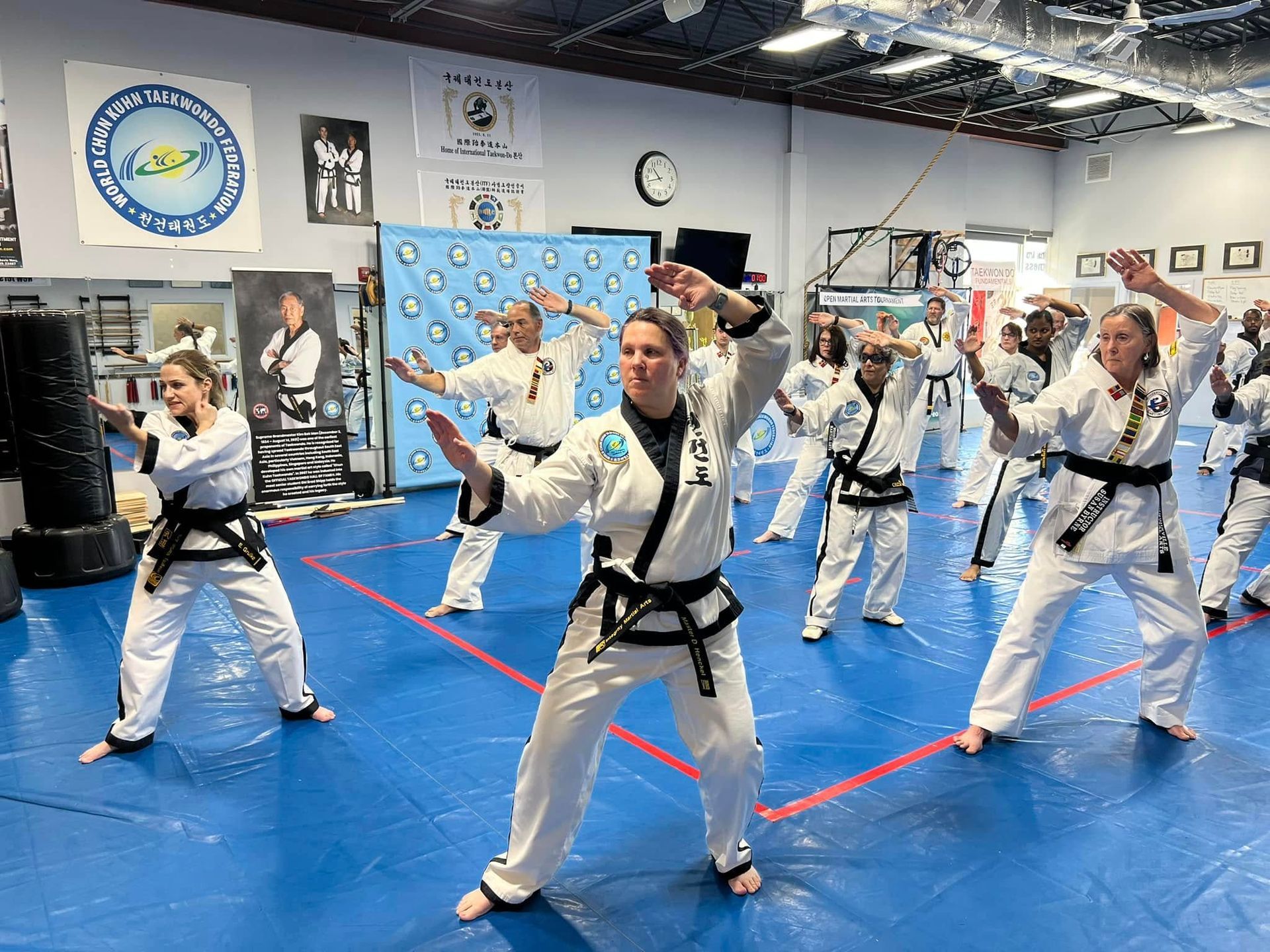A group of people are practicing martial arts in a gym.