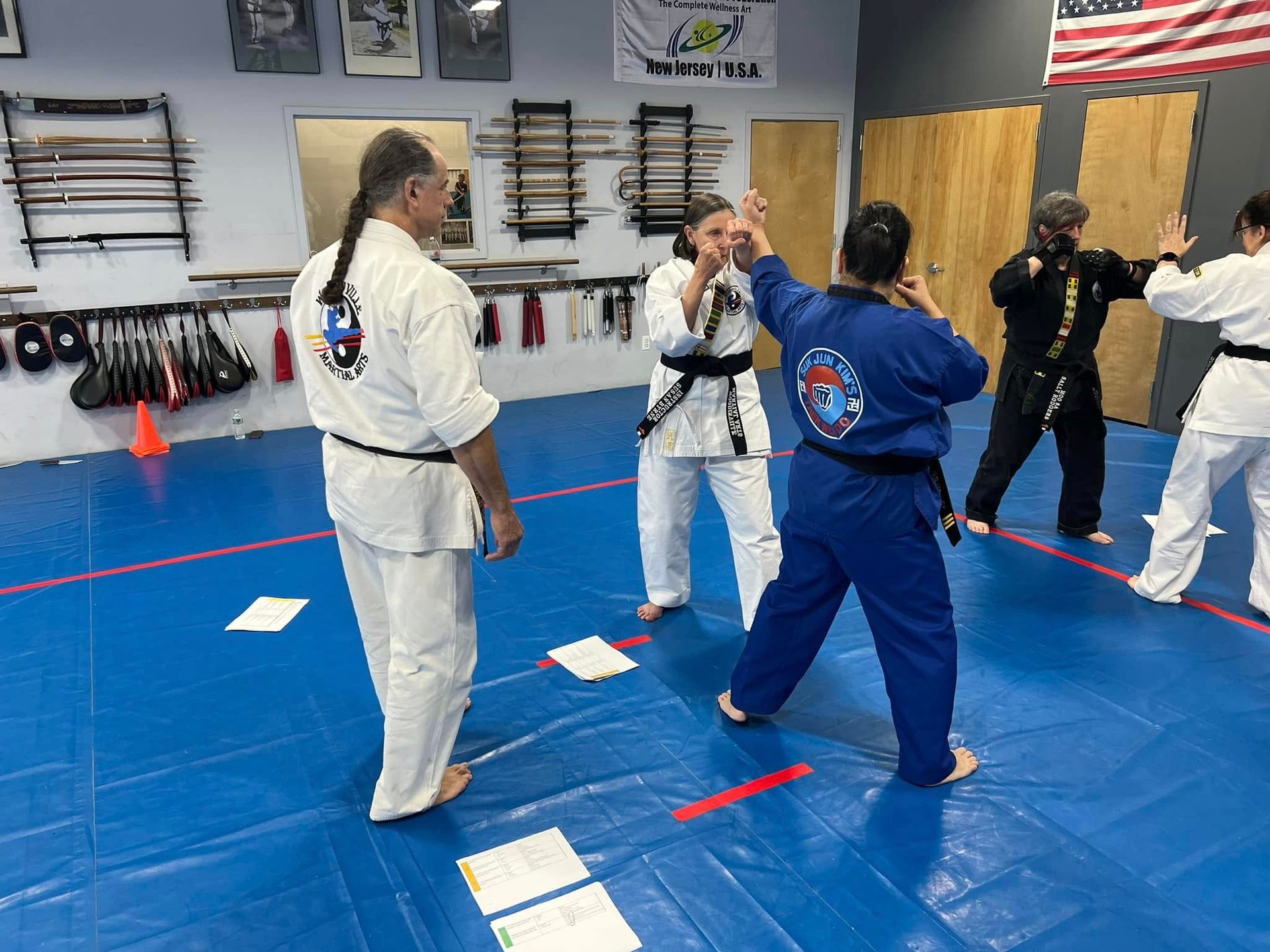A group of people are practicing martial arts in a gym.