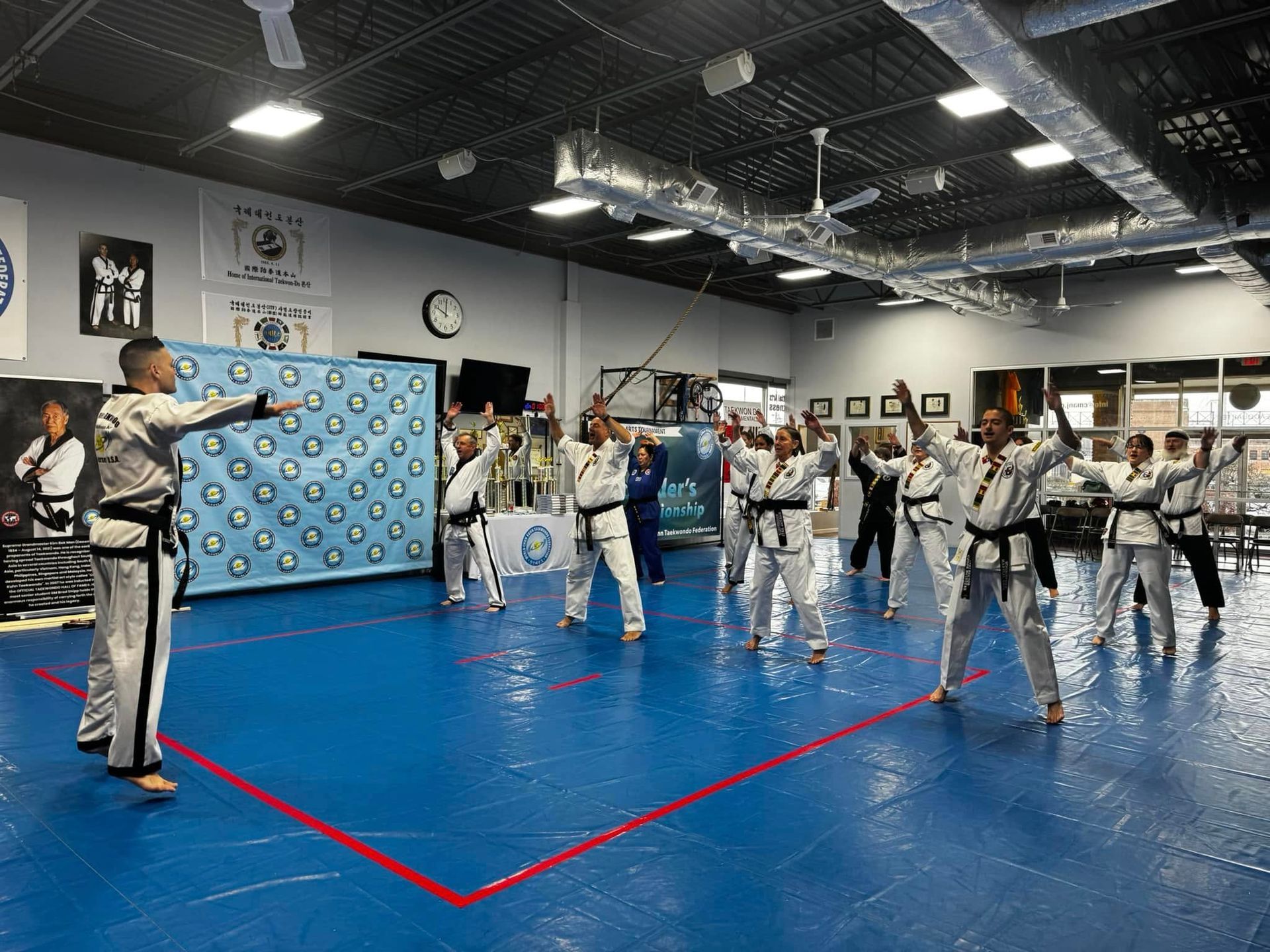 A group of people are practicing martial arts in a gym.