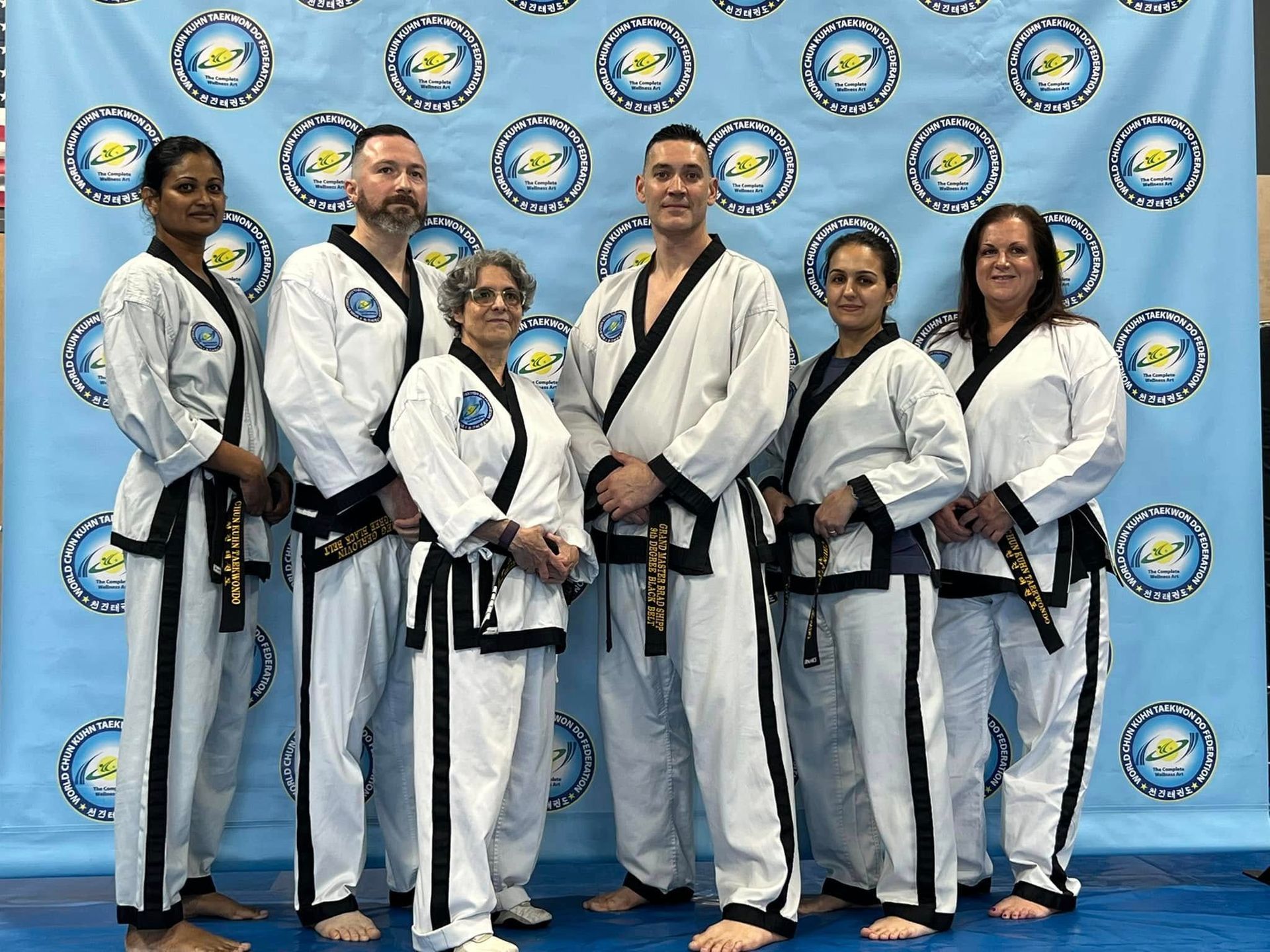 A group of people in martial arts uniforms are posing for a picture.