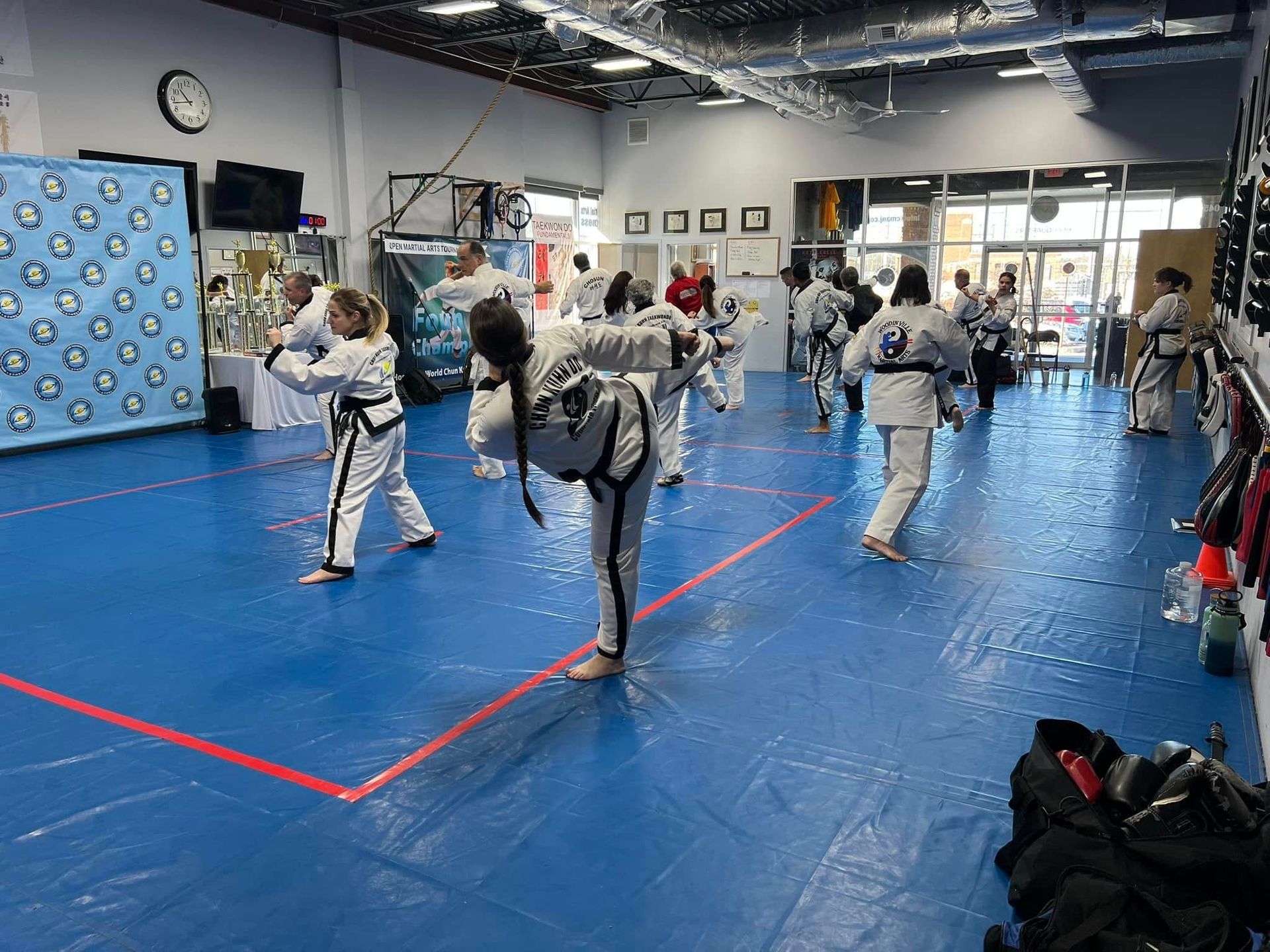 A group of people are practicing martial arts in a gym.
