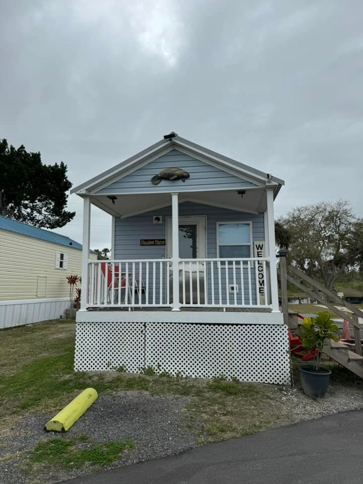 A small house with a porch and a fish on the roof