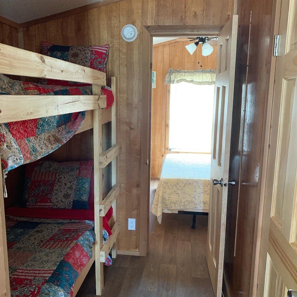 A bedroom with bunk beds and a bed in the corner
