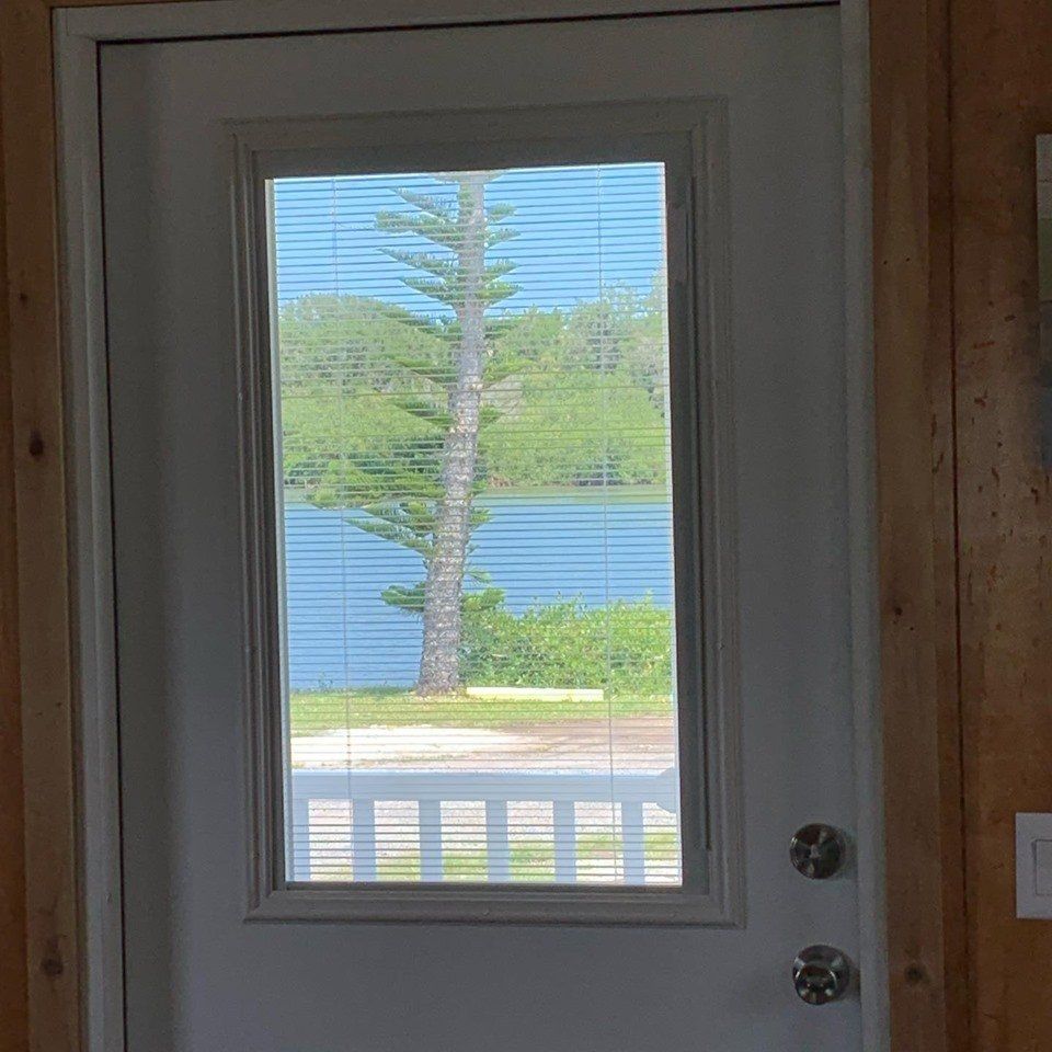 A door with a view of a lake through a window.