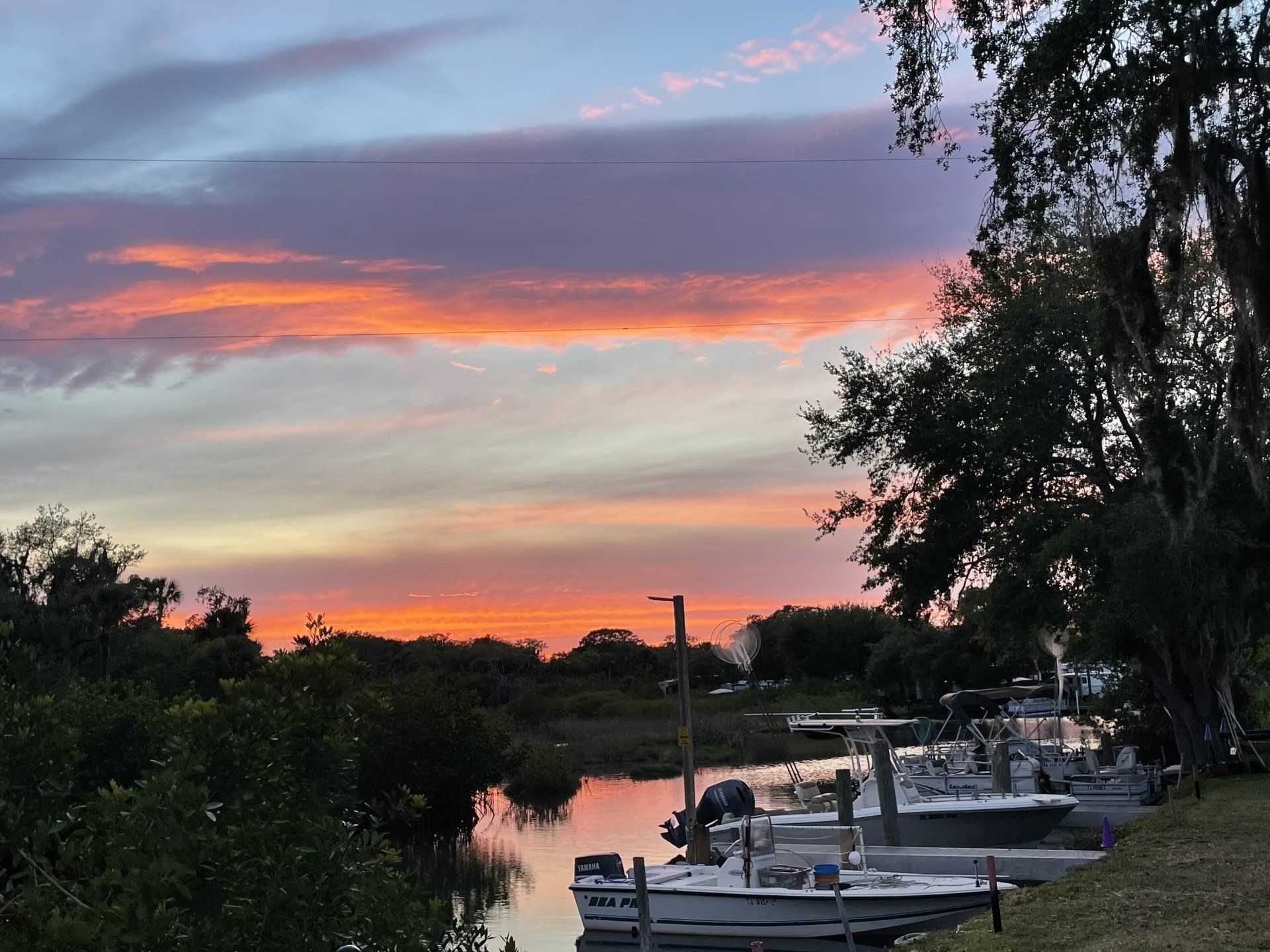 A sunset over a body of water with boats docked