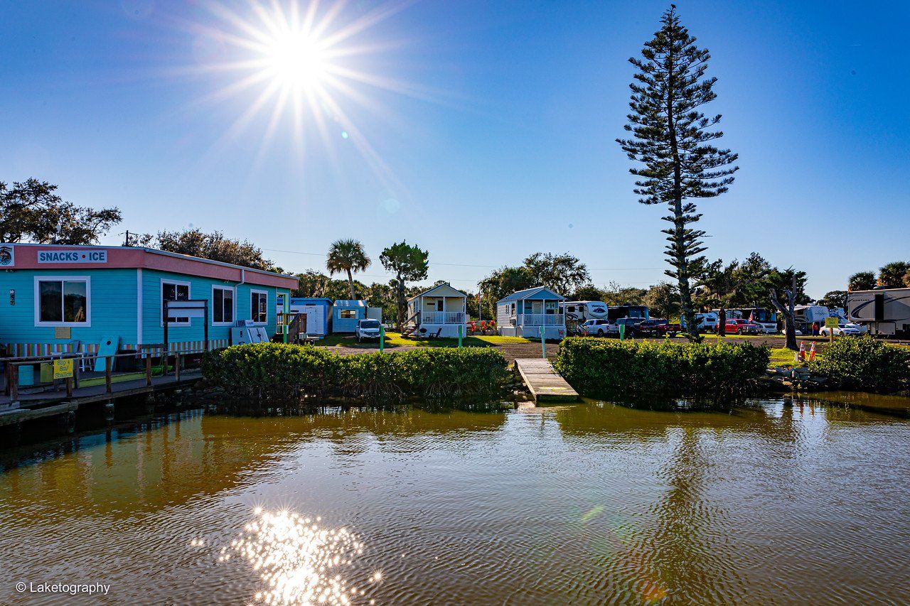 A group of houses are sitting next to a body of water.