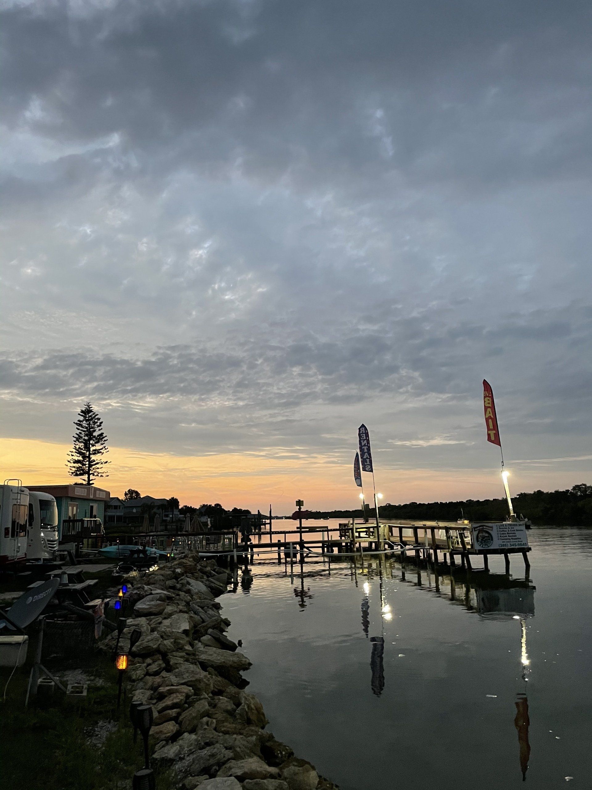 A sunset over a body of water with a dock in the foreground.