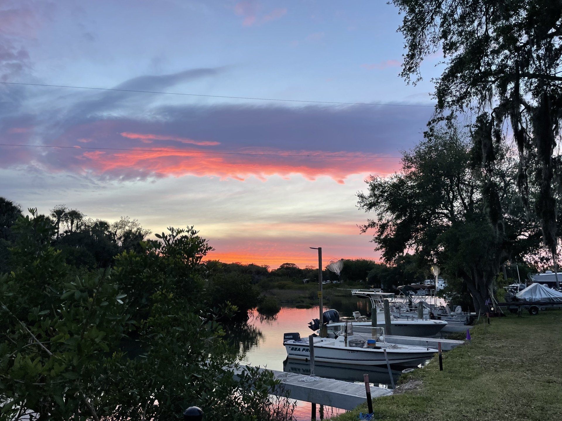 A sunset over a body of water with boats docked