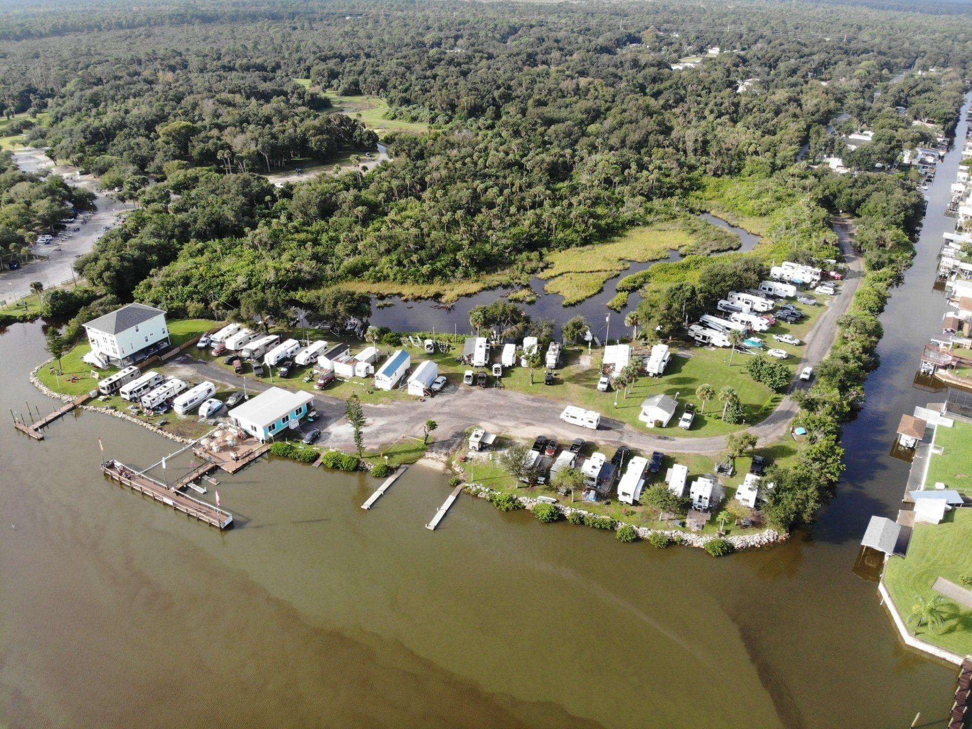 An aerial view of a small island in the middle of a body of water surrounded by trees.