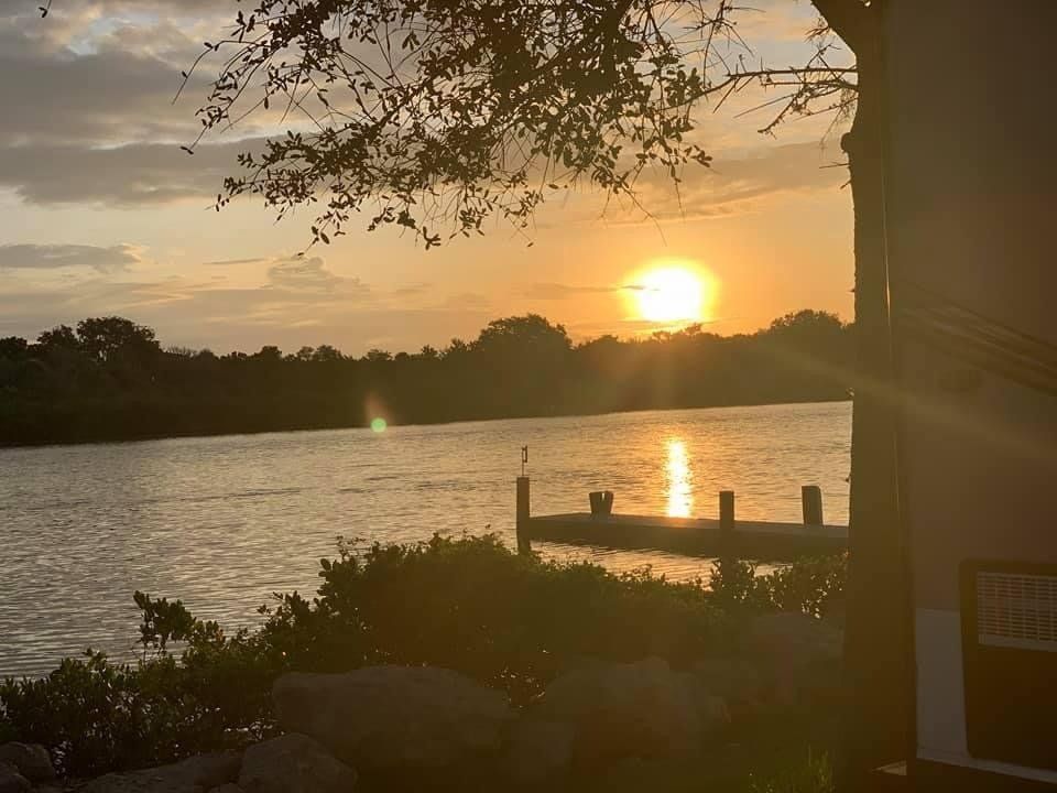 A sunset over a lake with a dock in the foreground
