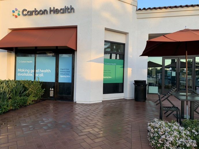 A white building with a sign that says carbon health