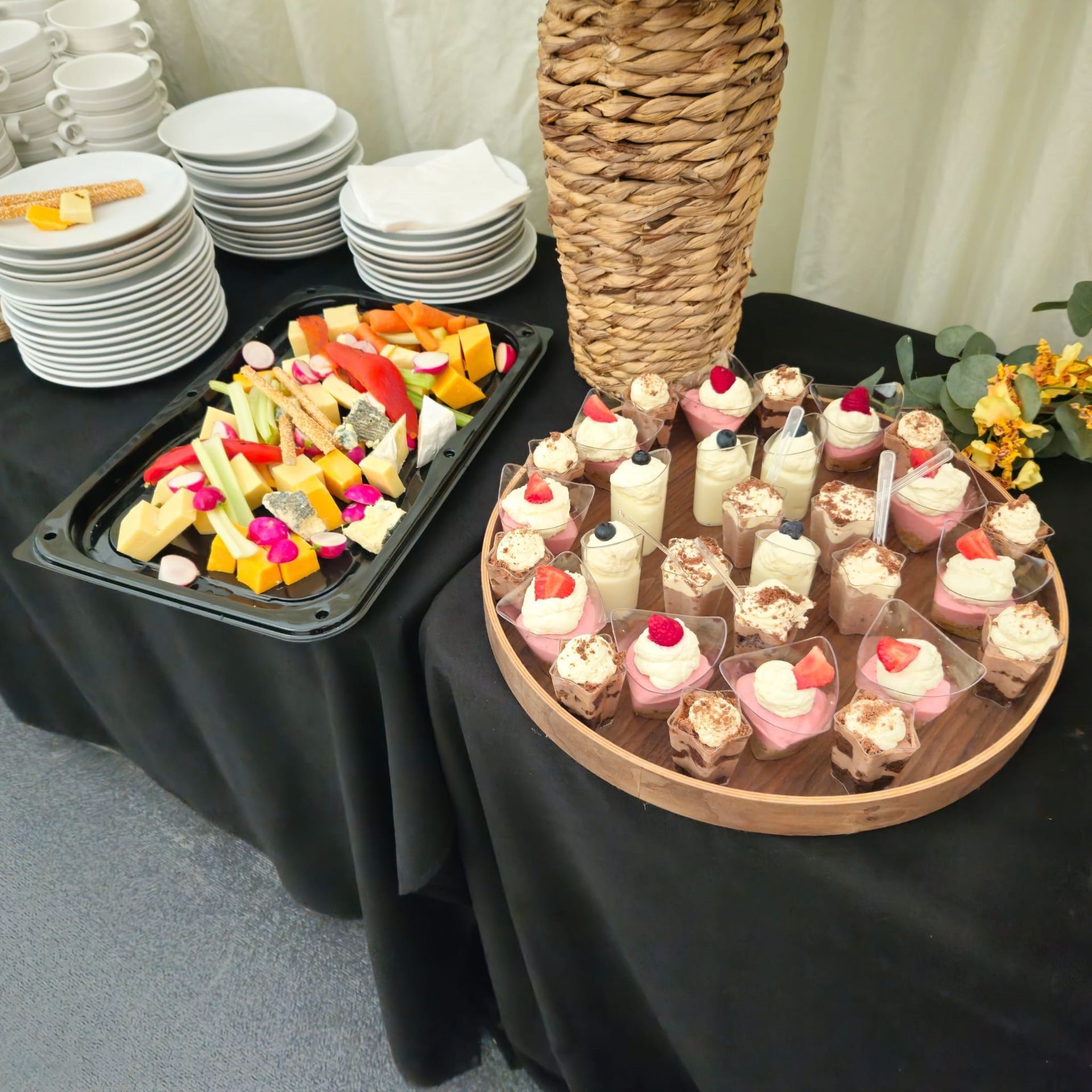 A table with a tray of fruit and a tray of desserts