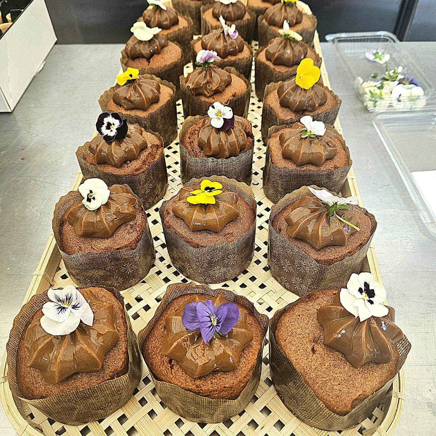 A tray of chocolate cupcakes with flowers on top