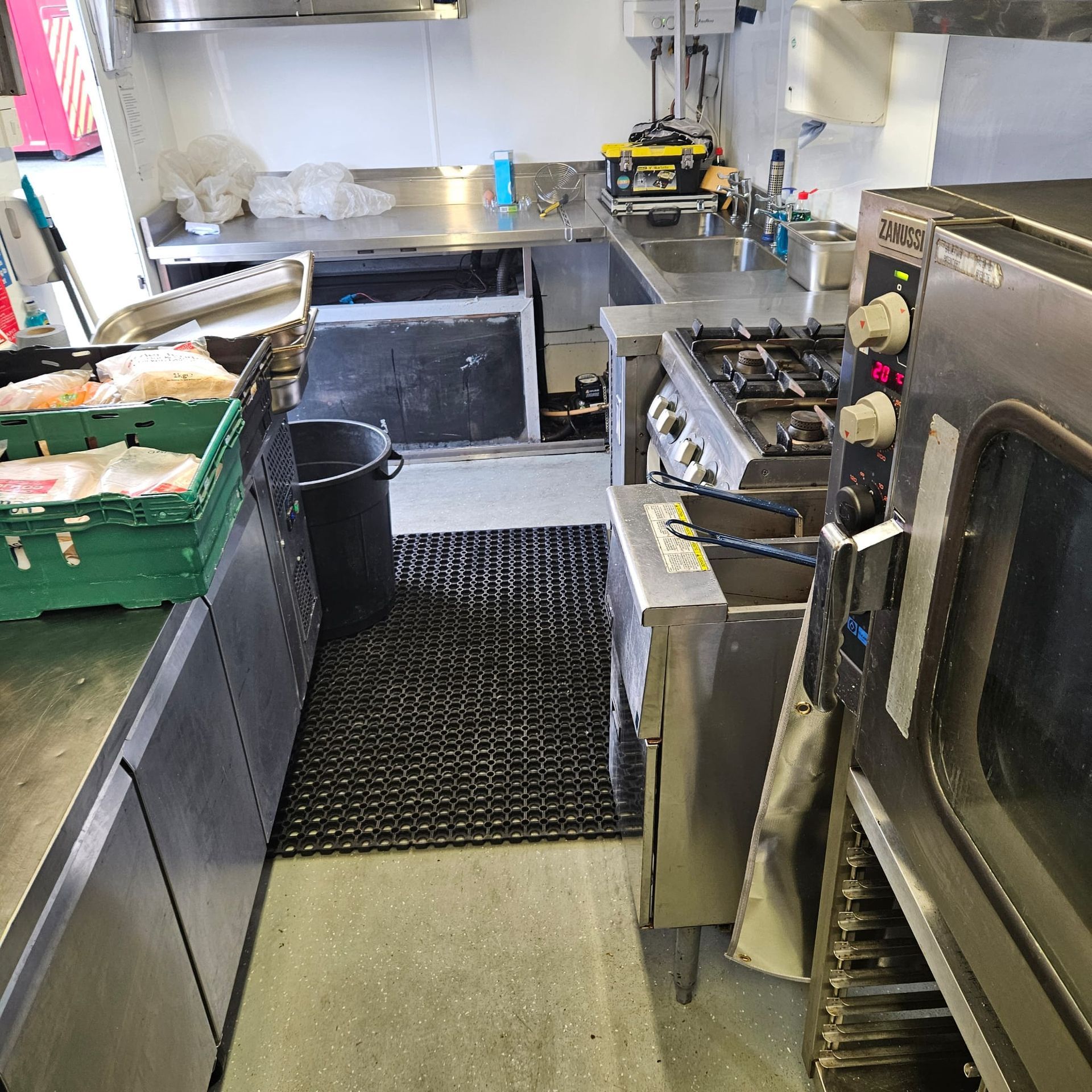 A man is standing in a kitchen looking at his phone.