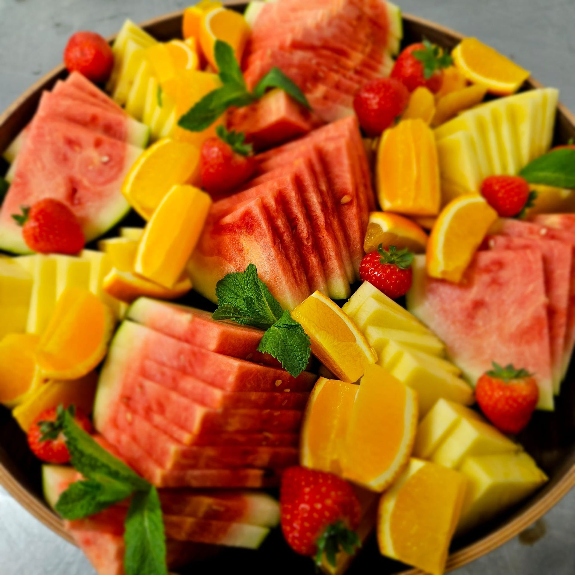 A bowl filled with watermelon strawberries and oranges