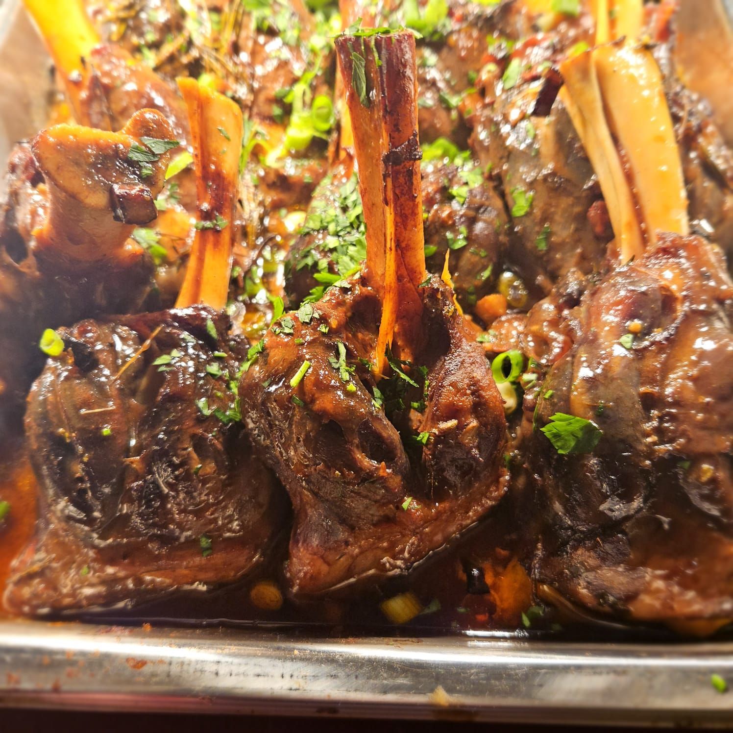 A close up of a tray of meat and vegetables on a table.