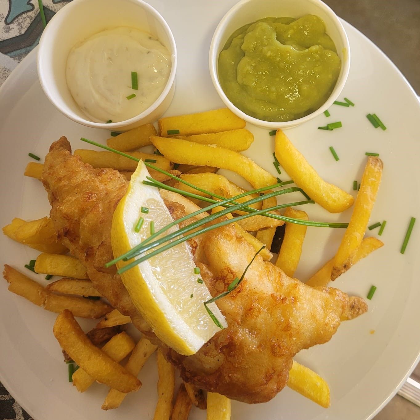 A white plate topped with fish and french fries