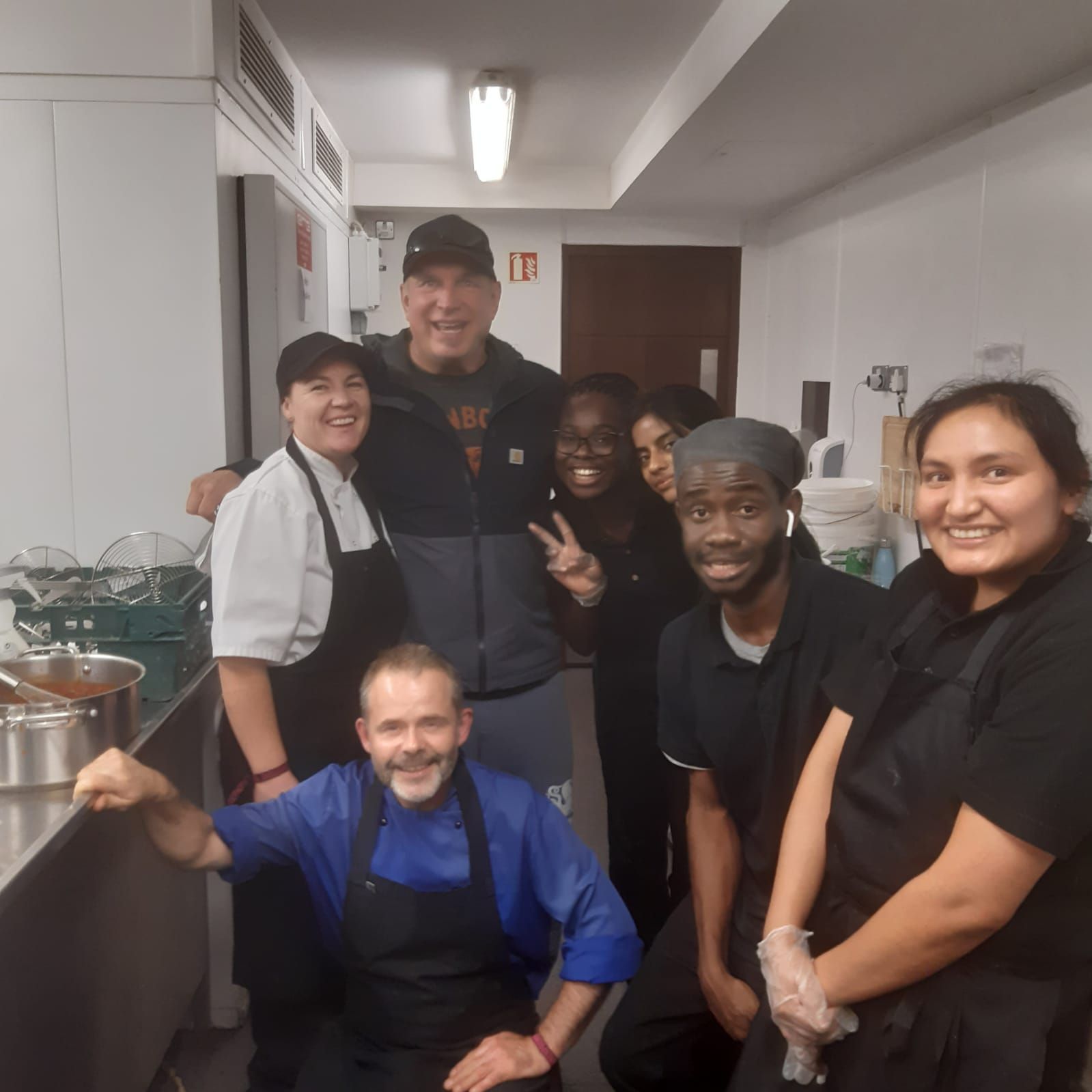A group of people posing for a picture in a kitchen