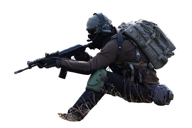 Un soldat en tenue tactique s'agenouille et vise un fusil sur le terrain.