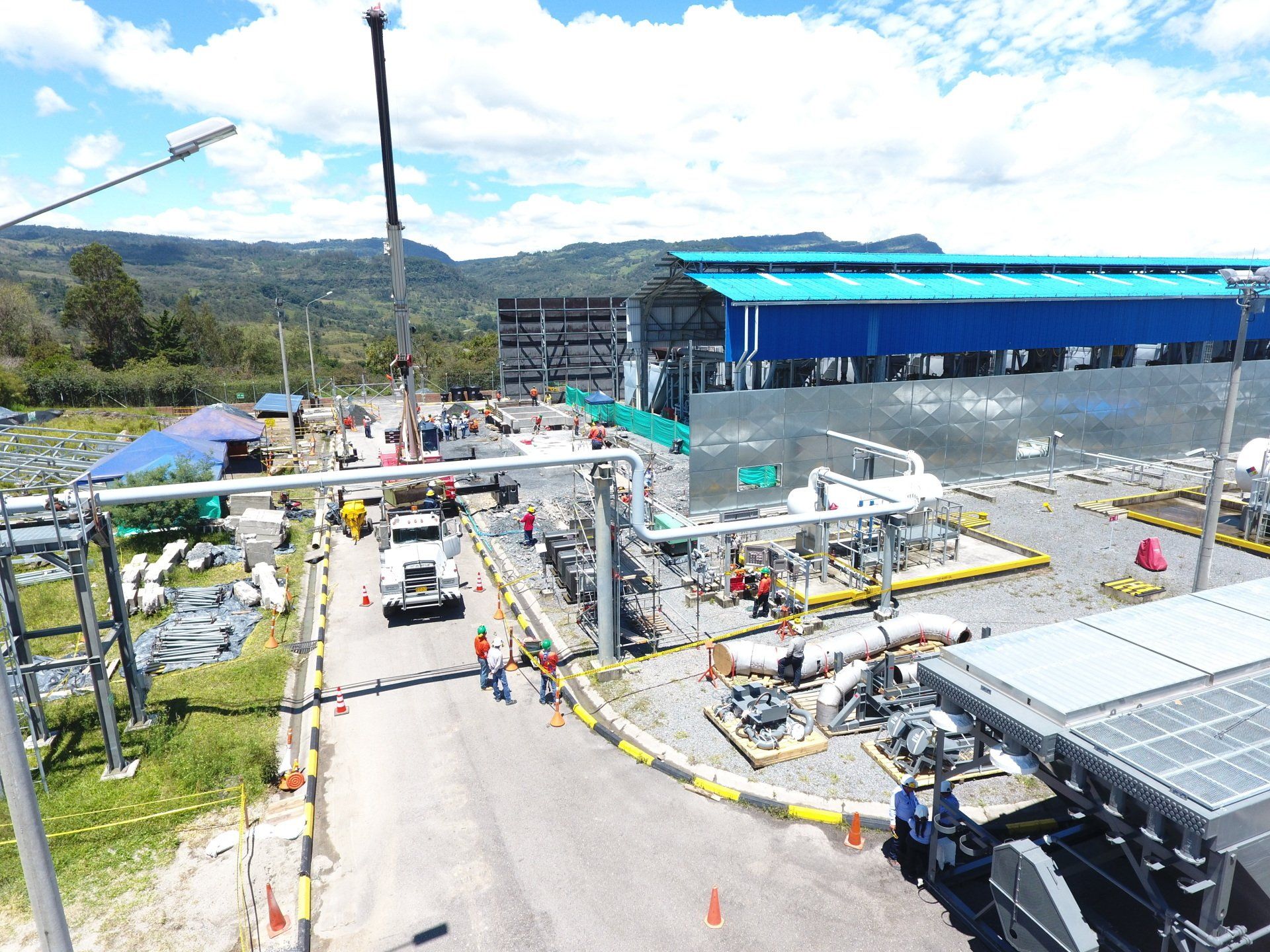 Una vista aérea de un sitio de construcción con un edificio azul en el fondo.