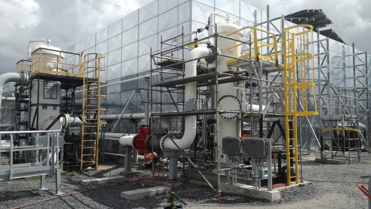 Un edificio grande con muchas tuberías y andamios a su alrededor.