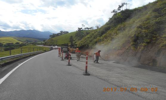 Un grupo de personas está trabajando al costado de una carretera.