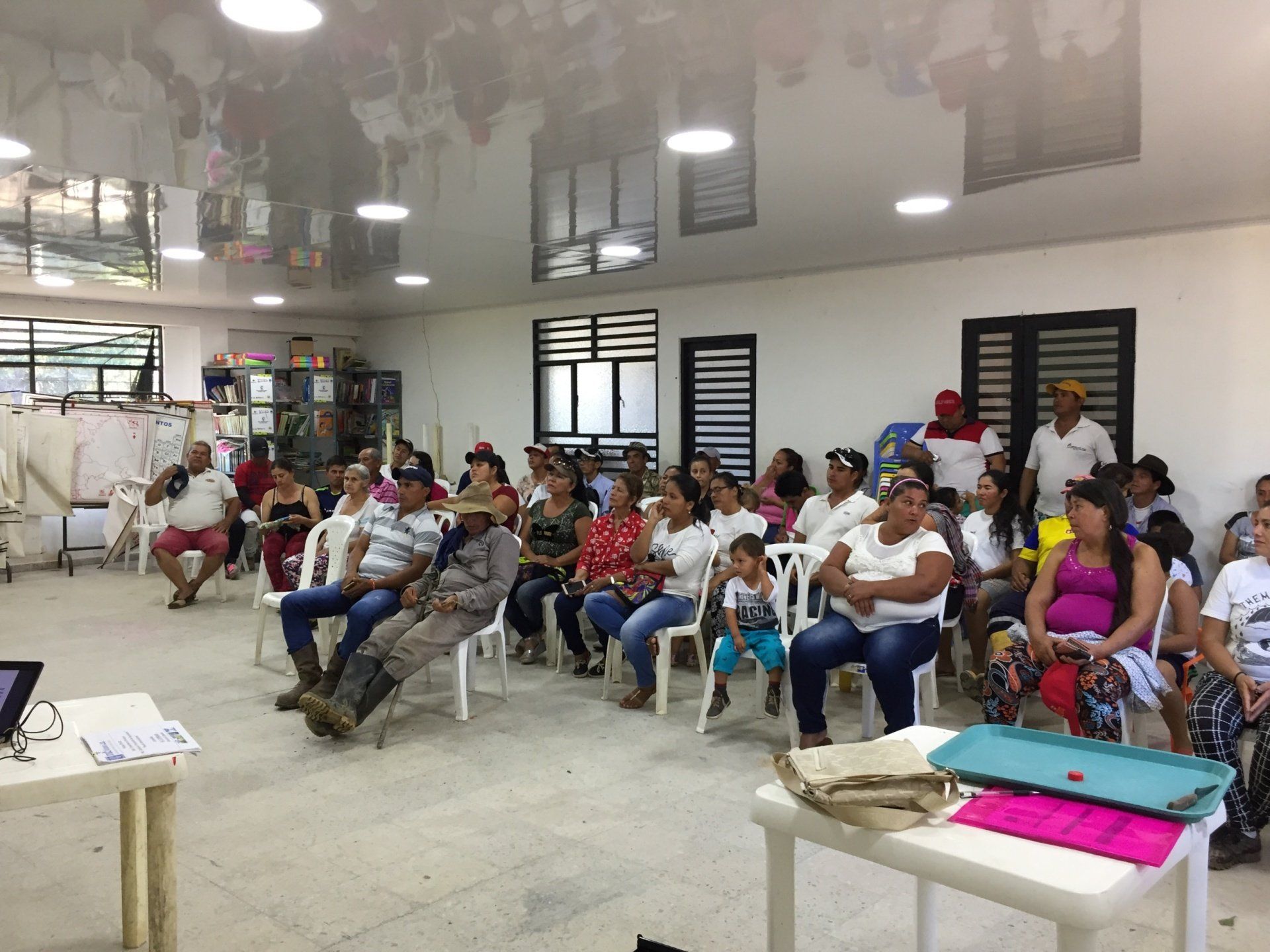 Un grupo grande de personas están sentadas en sillas en una habitación.