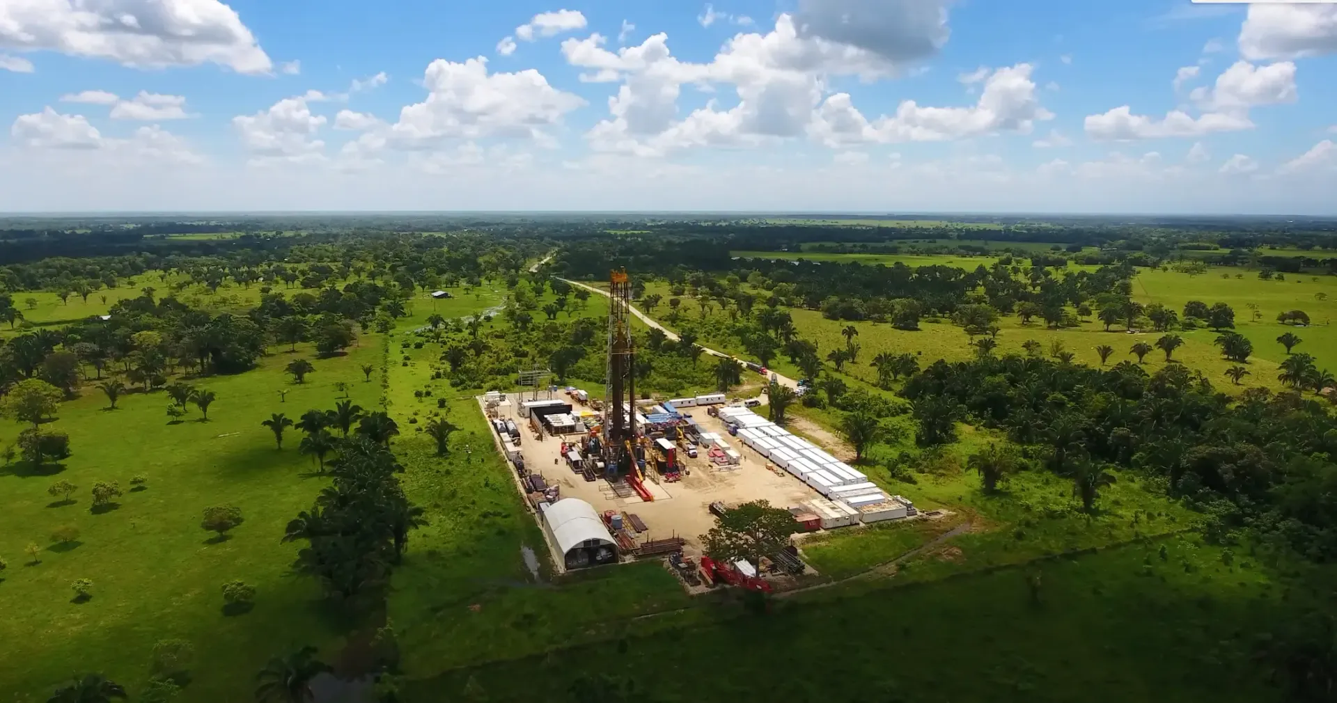 Una vista aérea de una plataforma petrolera en medio de un campo de hierba.