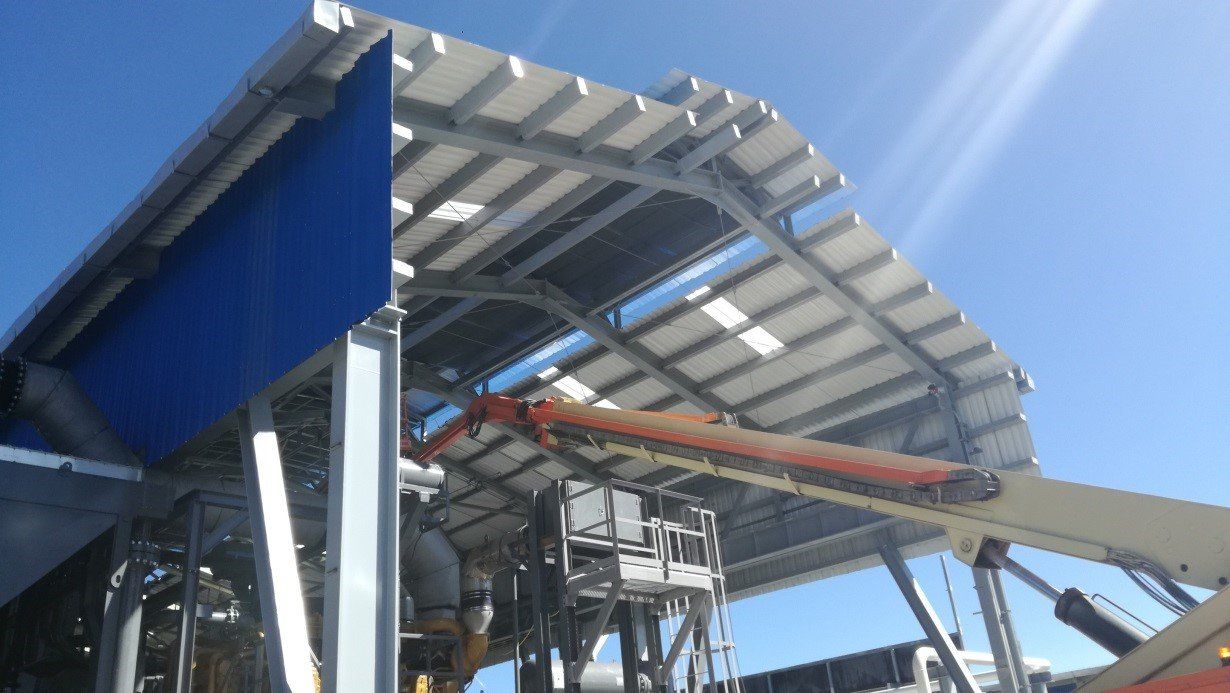 Una grúa está sentada debajo del techo de un edificio.