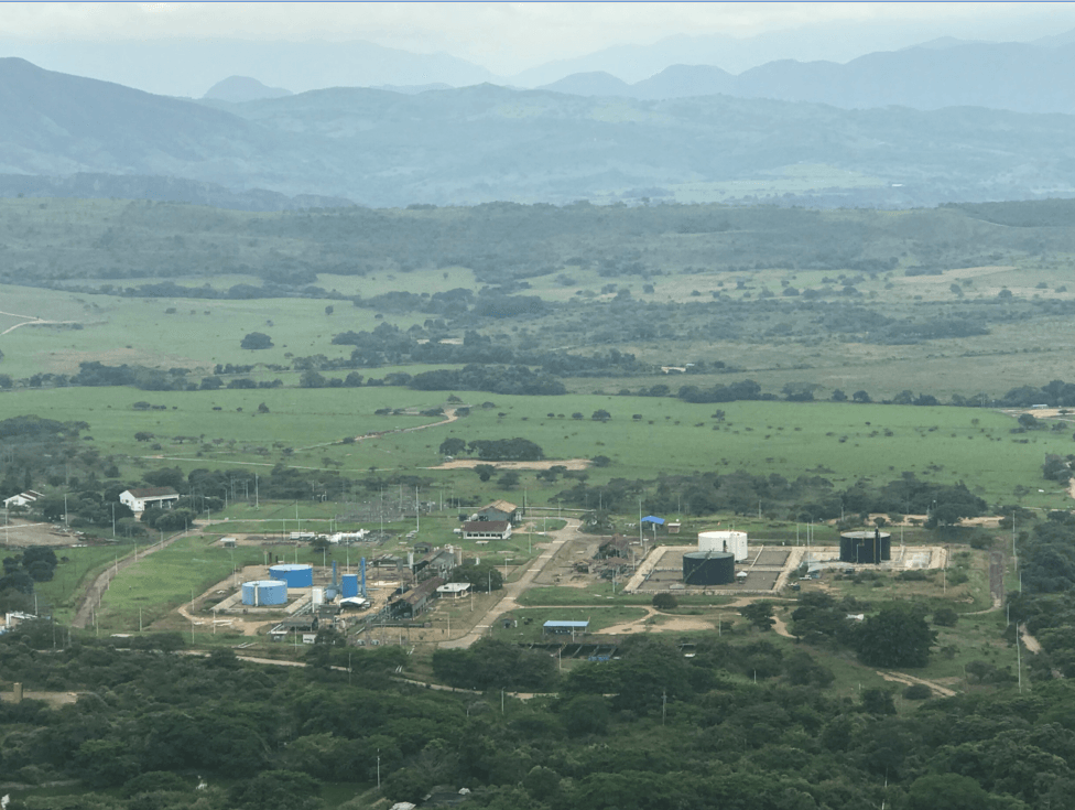 Una vista aérea de un campo con montañas al fondo.