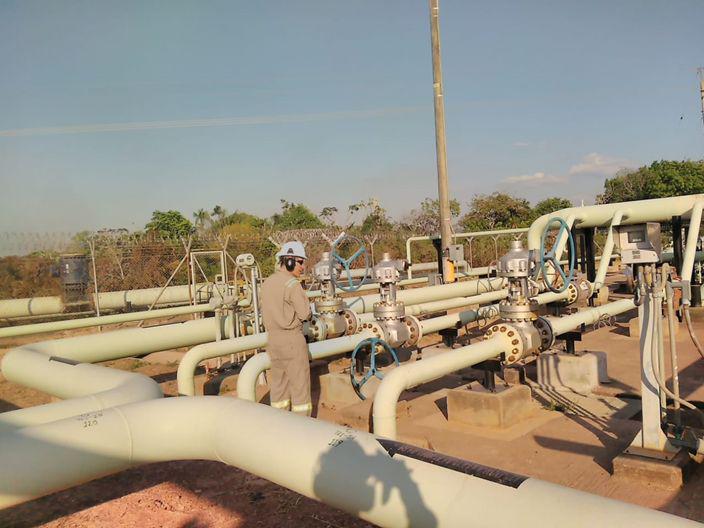 Un hombre está parado frente a un montón de tubos.